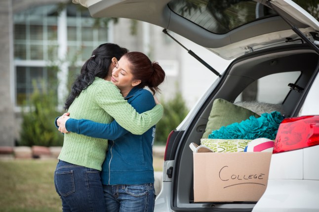 Hispanic mother helping daughter pack for college