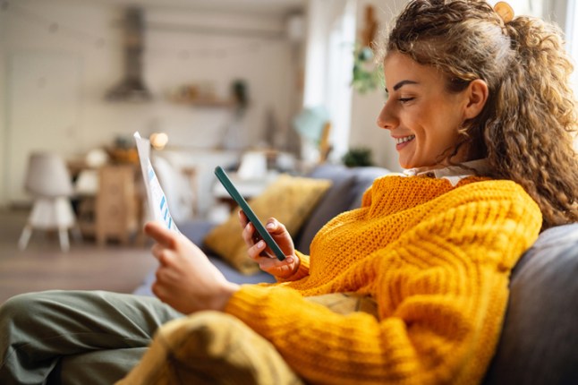 Young woman using e-banking to pay bills from home