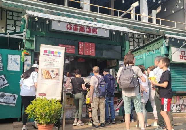 An Asian location for Mammy Pancake with people queuing for food